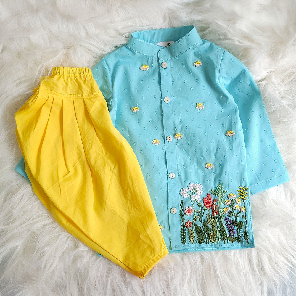 blue kurta with floral embroidery and yellow salwar pants on a white fluffy surface