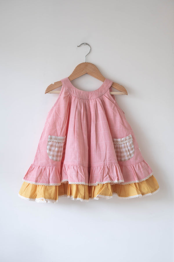 Pocketful of sunsets' sleeveless dress in peach pink with yellow frill in handwoven cotton