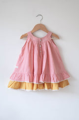 Pocketful of sunsets' sleeveless dress in peach pink with yellow frill in handwoven cotton